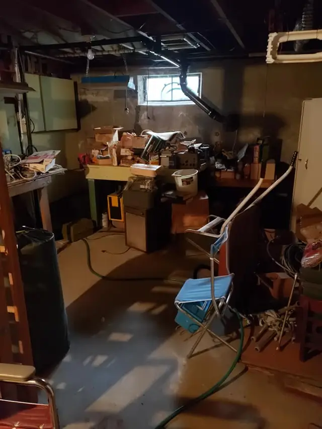 Cluttered basement with tools and furniture before a cleanout