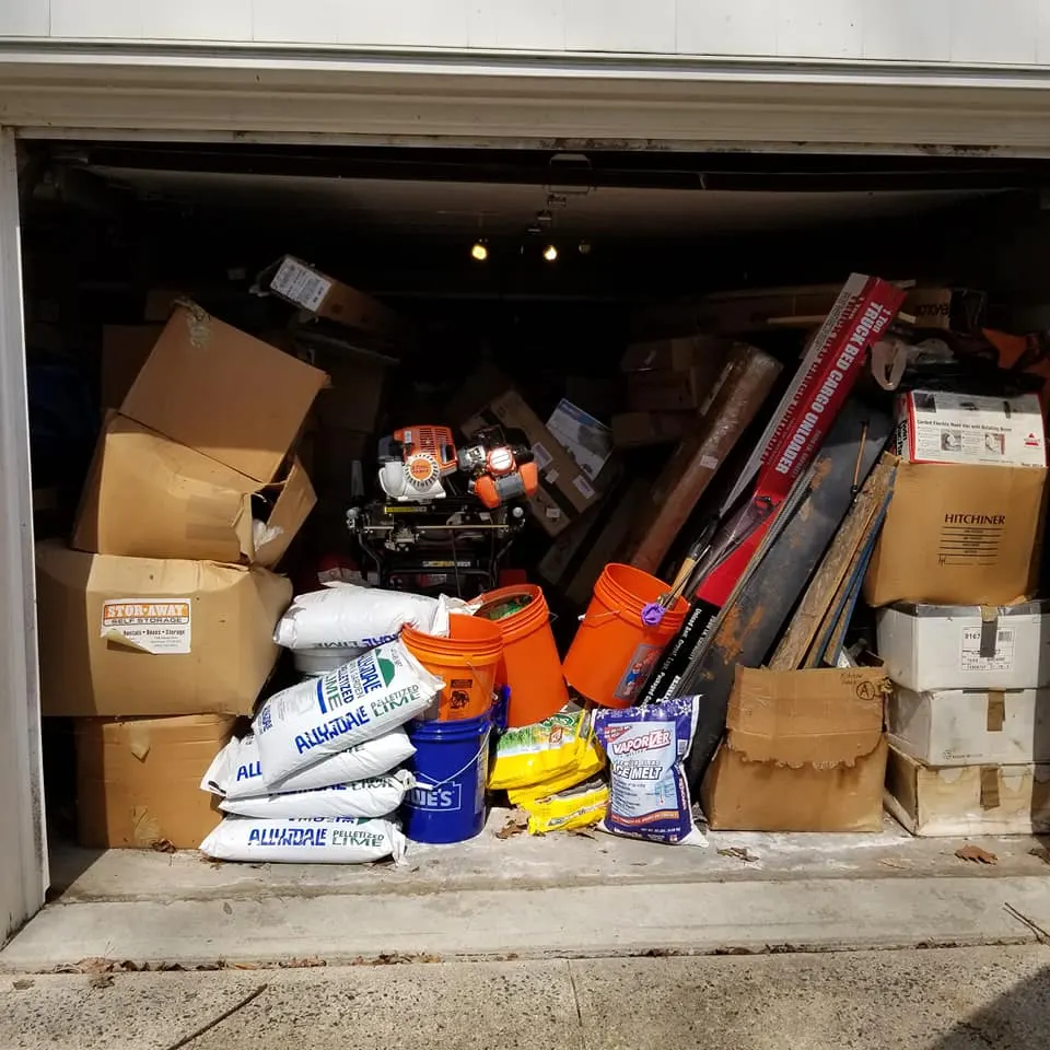 Garage packed with boxes and tools before a junk removal job in Connecticut