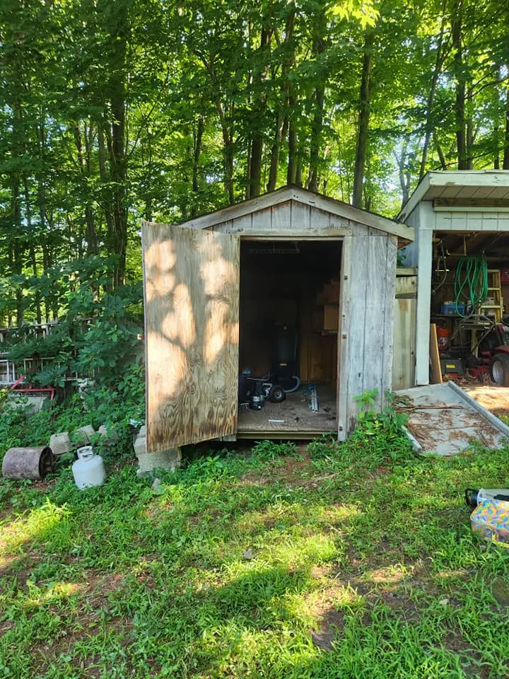 Weathered wooden shed in a Connecticut backyard before demolition